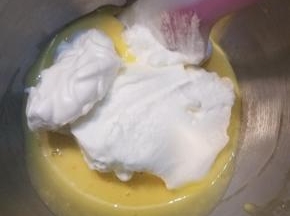 把搅打好的蛋白分三次加入蛋黄糊中，翻拌均匀