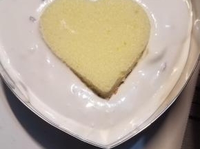 在慕斯圈内放入蛋糕底，然后倒入大部分慕斯糊，再压一块小一点的蛋糕片放入慕斯糊内，最后把剩余的慕斯糊倒入，涂抹均匀
