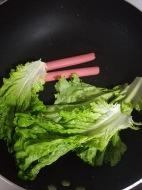 生菜用油煎一下。火腿肠也煎一下。