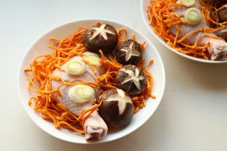 放上虫草菇，这个也叫虫草花。和冬虫夏草不是一回事，但有少许相同的功效。摆上葱段和姜片。