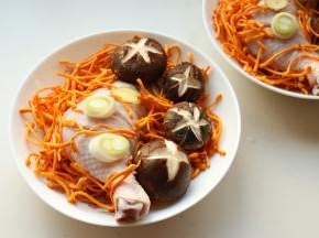 放上虫草菇，这个也叫虫草花。和冬虫夏草不是一回事，但有少许相同的功效。摆上葱段和姜片。