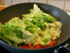 将包菜入锅炒。
