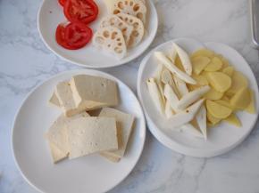 提前将豆腐切大片，藕去皮切薄片，土豆切厚片，山药切滚刀块，西红柿切厚片