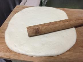 可协助擀面杖擀压出气体，揉成圆团覆盖保鲜膜松弛15分钟