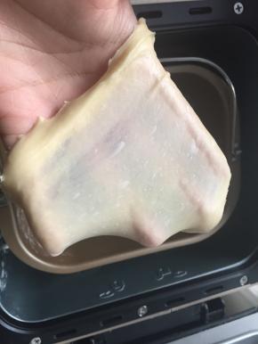 揉好的面团取出一小团，拉着面团两段轻往两边拉出易破薄膜，洞周边有带齿边