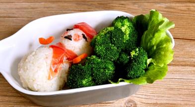 再将生菜叶放入圣诞老人的一边，上面放入汆烫后的西兰花