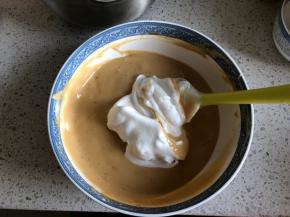 再取1/3的蛋白霜到蛋黄糊中，继续翻拌均匀