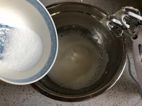 打发到蛋清泡沫细腻，再倒入1/3的细砂糖，继续中高速打发