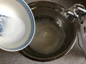 打发到蛋清泡沫细腻，再倒入1/3的细砂糖，继续中高速打发