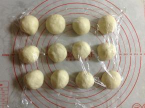 然后把面团取出，平均分成12份，盖上保鲜膜松弛10分钟。