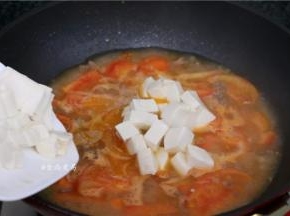 倒入豆腐，用锅铲将豆腐轻轻推入汤中