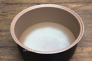 大米掏干净，倒入电饭锅内，加上高出大米3—4厘米左右的清水，接通电源，选择煲粥功能
