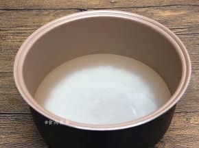大米掏干净，倒入电饭锅内，加上高出大米3—4厘米左右的清水，接通电源，选择煲粥功能