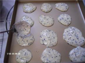 用汤匙挖少许调好的面糊，平铺在烤盘上，相互间要留较大的空间，以便摊平面糊，摆好面糊后，端起烤盘，上下左右轻轻摇晃一下，让面糊厚薄大小一致