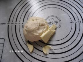 此时加入黄油，继续揉面团，直至黄油均匀地混入面团中