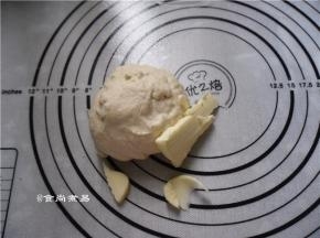 此时加入黄油，继续揉面团，直至黄油均匀地混入面团中