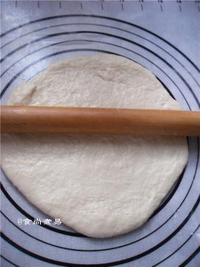 擀面杖涂抹一点黄油、防粘，取出面团，在案板上滚圆排气，盖上保鲜膜静置松弛15分钟，再用擀面杖擀薄至2厘米左右厚的圆饼