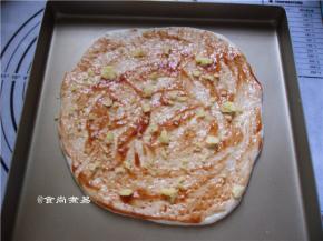 面饼上面涂抹一层番茄酱、撒些马苏里拉芝士碎