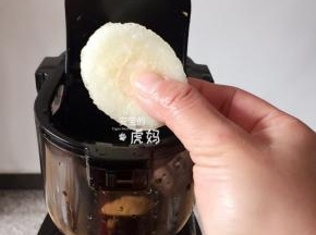 启动开关开始榨汁后，依次放入剩余的2个橙子，然后再把梨片全部放进去；