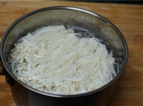 烧开适量水，水成沸腾状态时，放入金针菇，用筷子拌匀，焯水30秒钟左右快速捞起