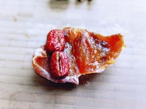 同样，将柿子饼去根，再切开，放上去核的红枣。再卷起来即可。