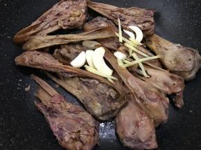 煸炒至带皮那面焦黄后加入姜丝和蒜片