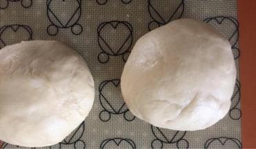 排气。
分成等分的两个面团。一个包好保鲜膜放置醒发。