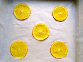 将橙片沥干水，摆在烤盘上