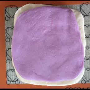 白色的面饼在下，紫色的在上面，用擀面杖轻轻的按压一下，使两个面饼充分接触。
