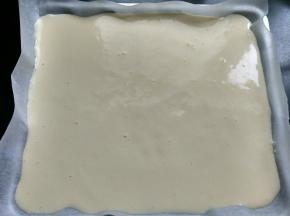 将油纸放入烤盘，将蛋糕糊从10cm的高处倒入烤盘，振动几下，振出气泡，将烤盘放入预热好的烤箱，上下火140度，30分钟。