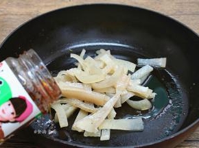 热锅，倒入食用油，将猪皮倒入锅中、调入香菇酱煸炒出香味；