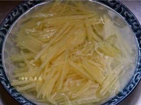土豆去皮切丝，用清水浸泡片刻，洗去淀粉质【淀粉质容易粘锅，用清水浸泡防止土豆丝氧化，发黑】