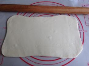 发酵好的面团取出排气，揉啊揉，大概揉8分钟，揉至面团光滑，切面没大气孔即可。如果面团有点粘手，可以在案板上洒点面粉。将面团擀成长方形，四个角擀开，翻面再擀擀，尽量弄成长方形吧