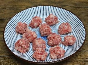 抓起肉糜，肉丸从虎口处挤出，搓好的丸子放在一旁待用