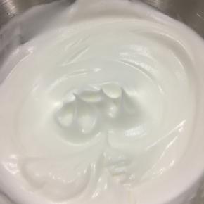 打发蛋白，分三次加入细砂糖60个，将蛋白打发到可以拉出直立尖角的干性发泡状态（如图）