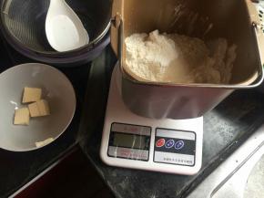 将材料除黄油和豆沙以外放入面包机桶，和面2次共20分钟后放入黄油，再和面一次10分钟