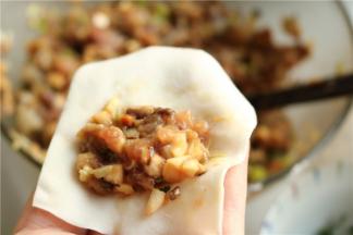 挖一勺肉馅，放在馄饨皮上。