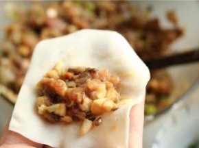 挖一勺肉馅，放在馄饨皮上。