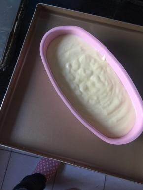 面糊倒入模具，震去大气泡，放在烤盘上，烤盘内加冷水