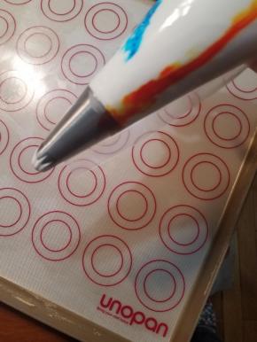 捏紧封口，将蛋白糊擀入前端，裱花袋剪口露出裱花嘴