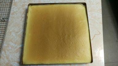 待有点余温，拿张油纸盖上，再翻过来，小心取下蛋糕，涂上紫薯泥或奶油，卷的时候借助擀面杖，一边把油纸卷入擀面杖，一边将蛋糕推成卷状，整个卷好用油纸包住，放冰箱冷藏2小时以上