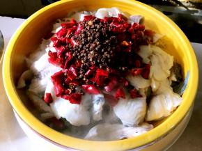 将辣椒切段、花椒都放到鱼肉上