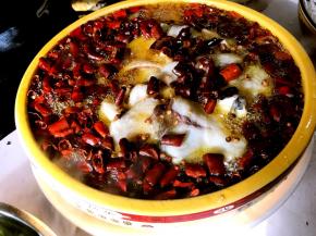 起锅放入所有的花生油烧热，浇到辣椒和花椒上，油一定要没过鱼才好