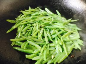 放入豆角丝迅速翻炒。