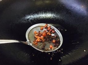 当花椒爆出香味，颜色见深时，把花椒和小米椒捞出不用，留炸好的油备用。
