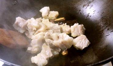 倒入五花肉，中火煎炒至表面微黄