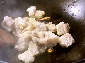 倒入五花肉，中火煎炒至表面微黄