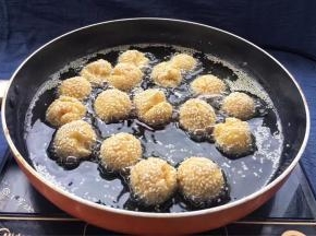 用筷子不停翻动锅中面团，让其受热均匀，炸至金黄色即可捞出沥干油份。