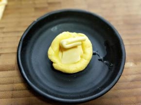 取一小块面团，掌心压扁，放上芝士片。