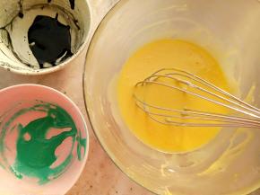 取两个干净的小碗，一个碗里放入1克竹炭粉用一点点水搅匀再放入2克的蛋黄糊，另一个碗里放2克的蛋黄糊再用牙签粘一点蓝色色素搅匀。